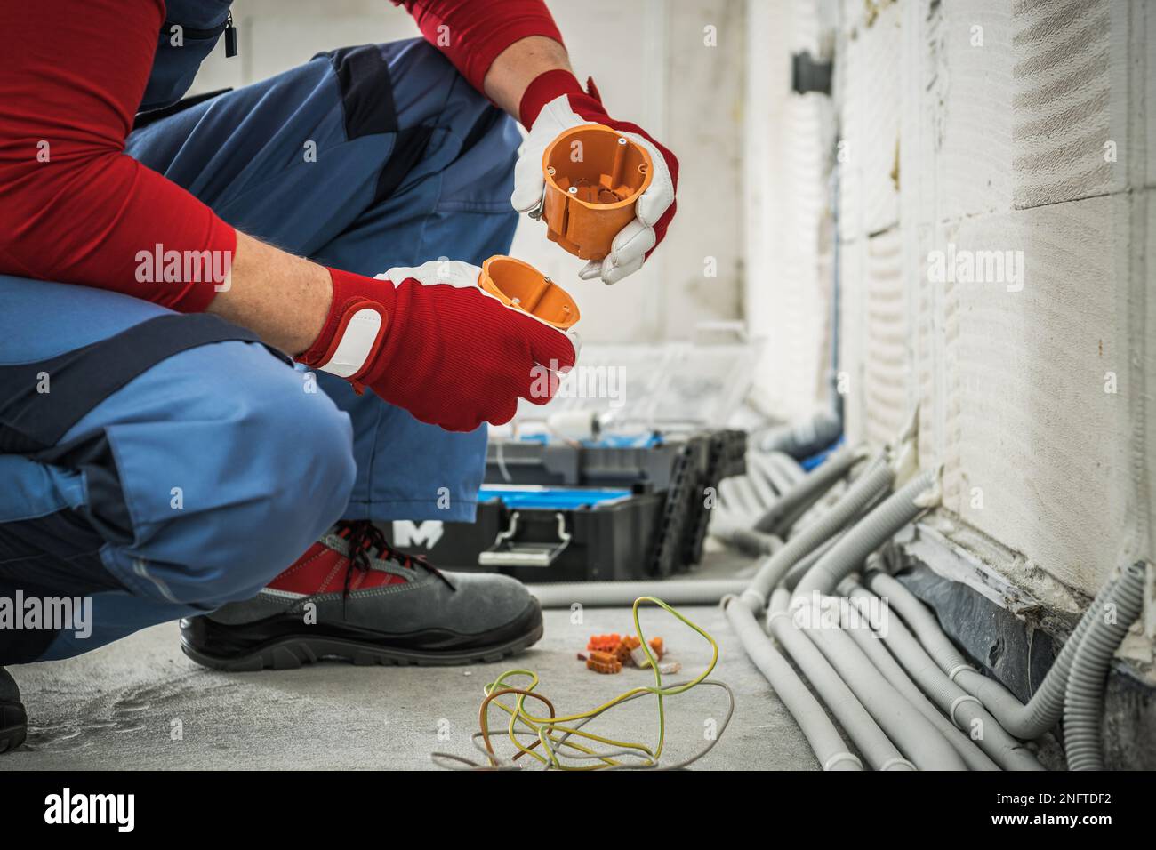 Caucasian Electrician Assembling Electrical Boxes During Wiring System