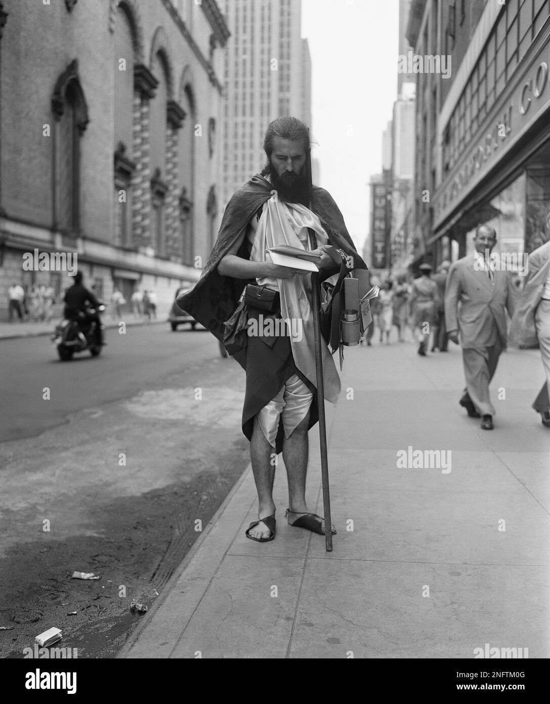 "Moondog" is the name this blind man gives himself. His eccentric costume is familiar around New York. He is seen at Seventh Avenue and 50th Street on August 19, 1952. He writes poetry and music in Braille. He hands out his compositions free but accepts contributions.(AP Phot/Robert Kradin) Stock Photo