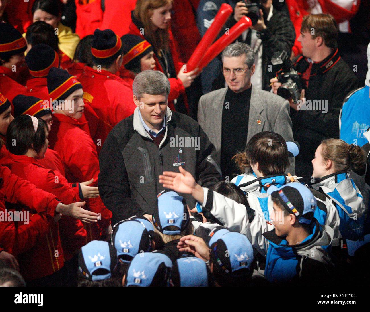 Prime Minister Stephen Harper, centre, shakes hands with athletes after