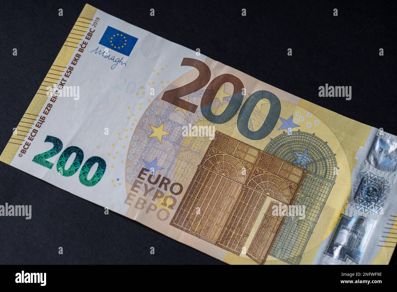 200 euro banknote close up on black background for business finance topics. World money concept, inflation and economy concept. Currency close up in d Stock Photo