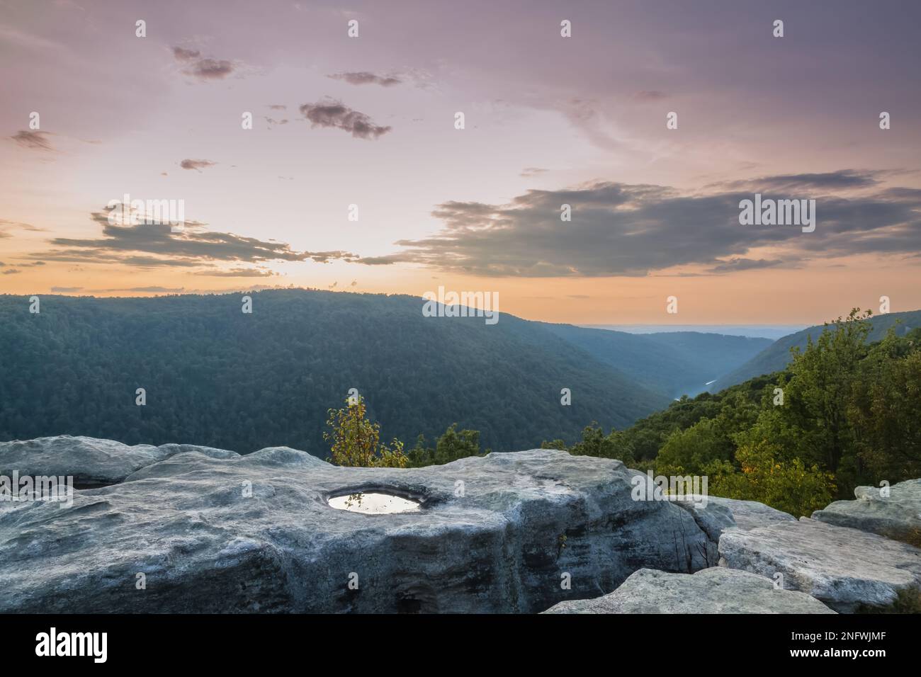 A Rock outcropping in West Virginia along the Cheat River with reflecting pool as sunset Stock Photo