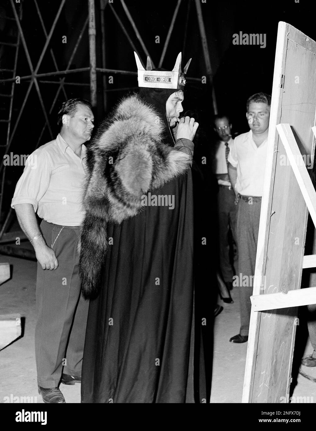 Orson Welles is shown between takes of the film "Macbeth," smoking a