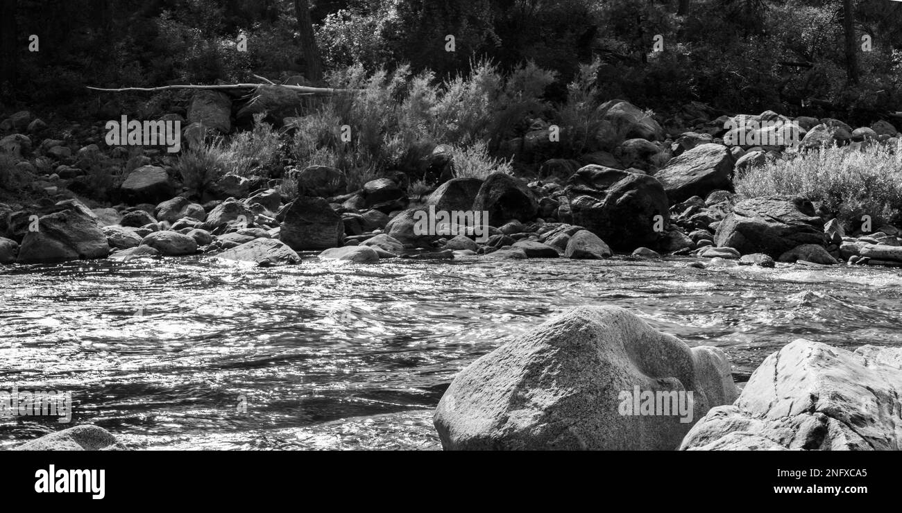 A grayscale of a flowing rocky river Stock Photo - Alamy