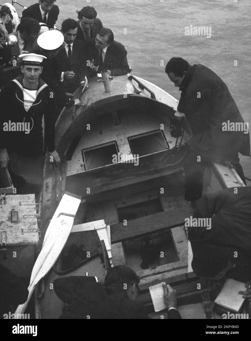 Newsmen and photographers surround Puffin, the boat in which David  Johnstone and John Hoare attempted to row across the Atlantic Ocean. HMCS  Chaudière found the floating vessel with no signs of life