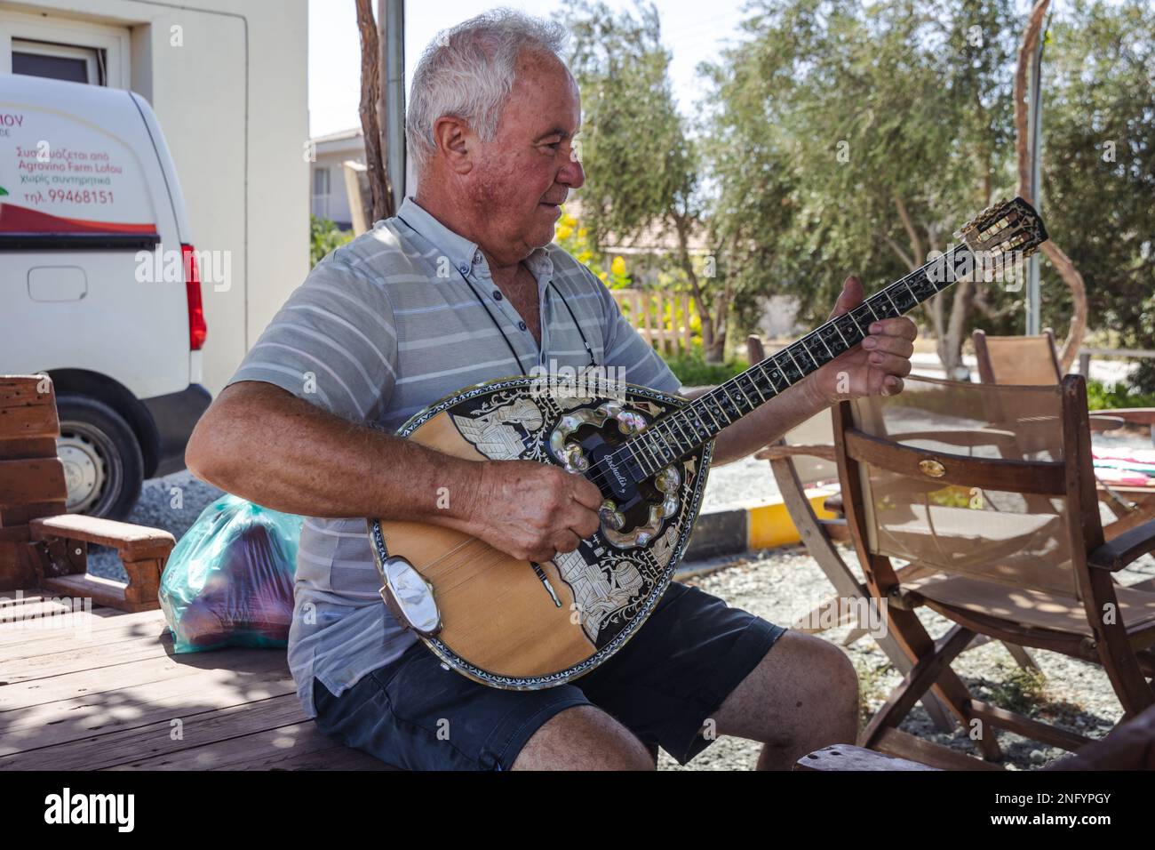 Mr Costas Violaris, owner of Agrovino Farm plays on a bouzouki in