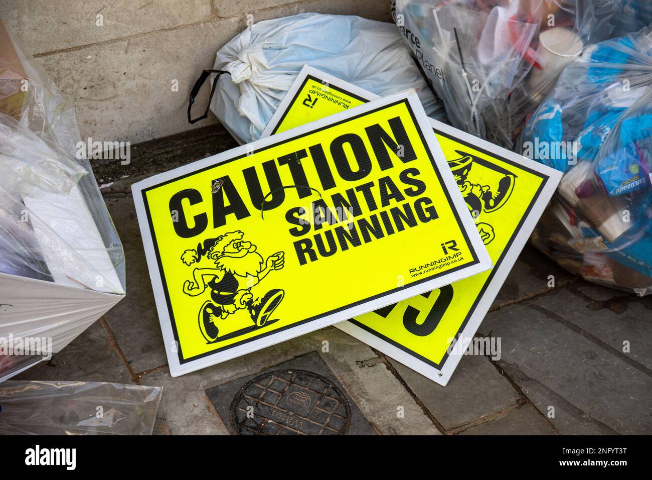 Caution. Santas running. Thrown away Santa Run warning signs in a trash
