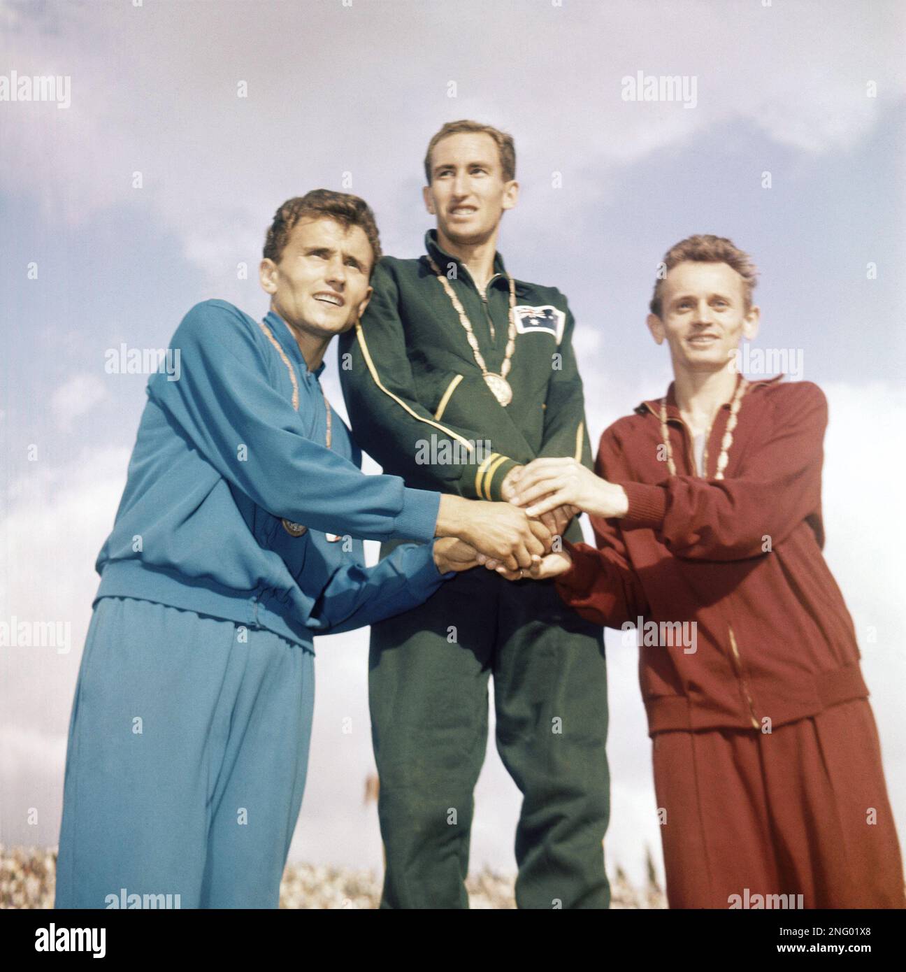 Herb Elliott, center, of Australia, at center, stands on the podium to