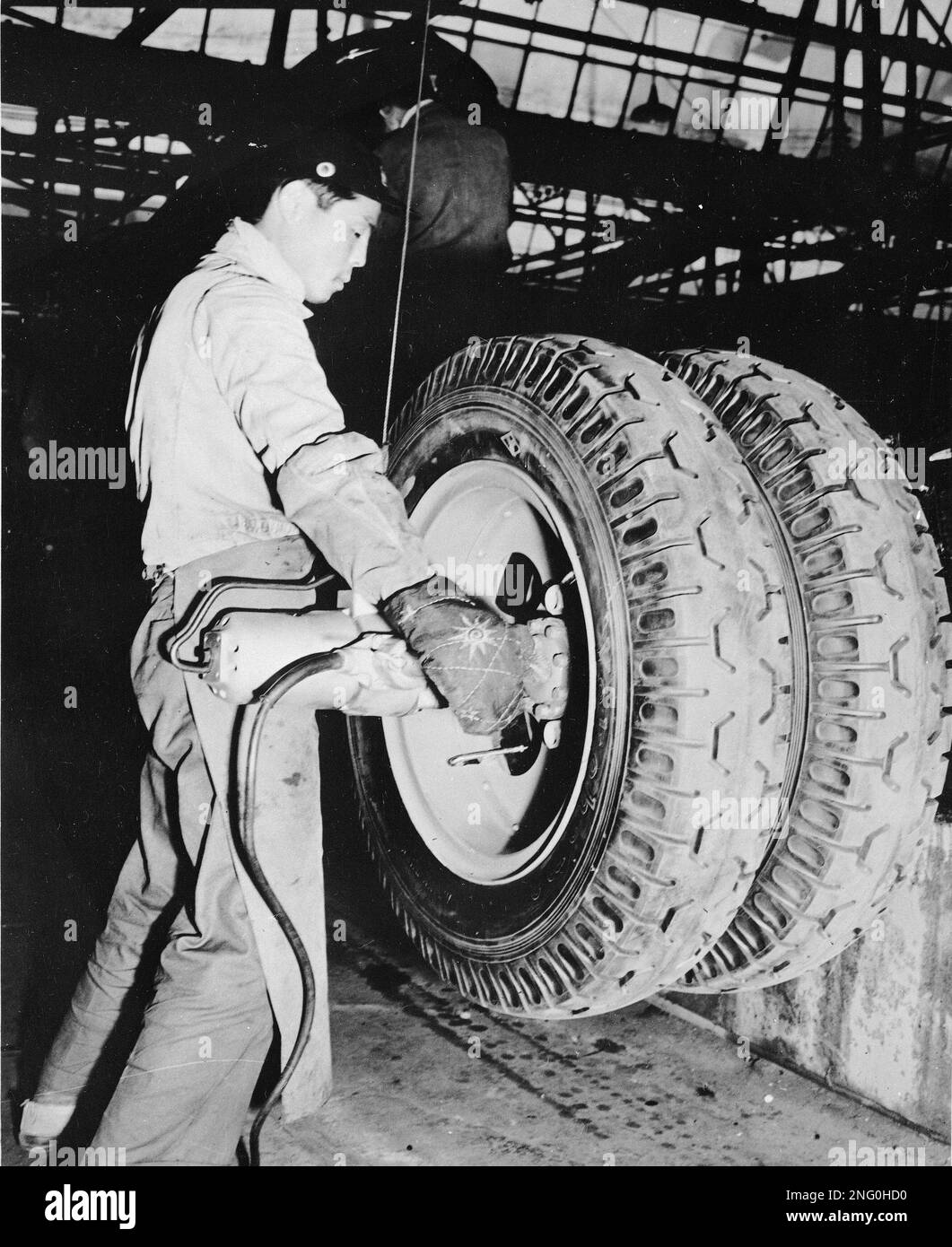 Wheel nuts are tightened by a pnumatic wrench at the Nissan Motor Works