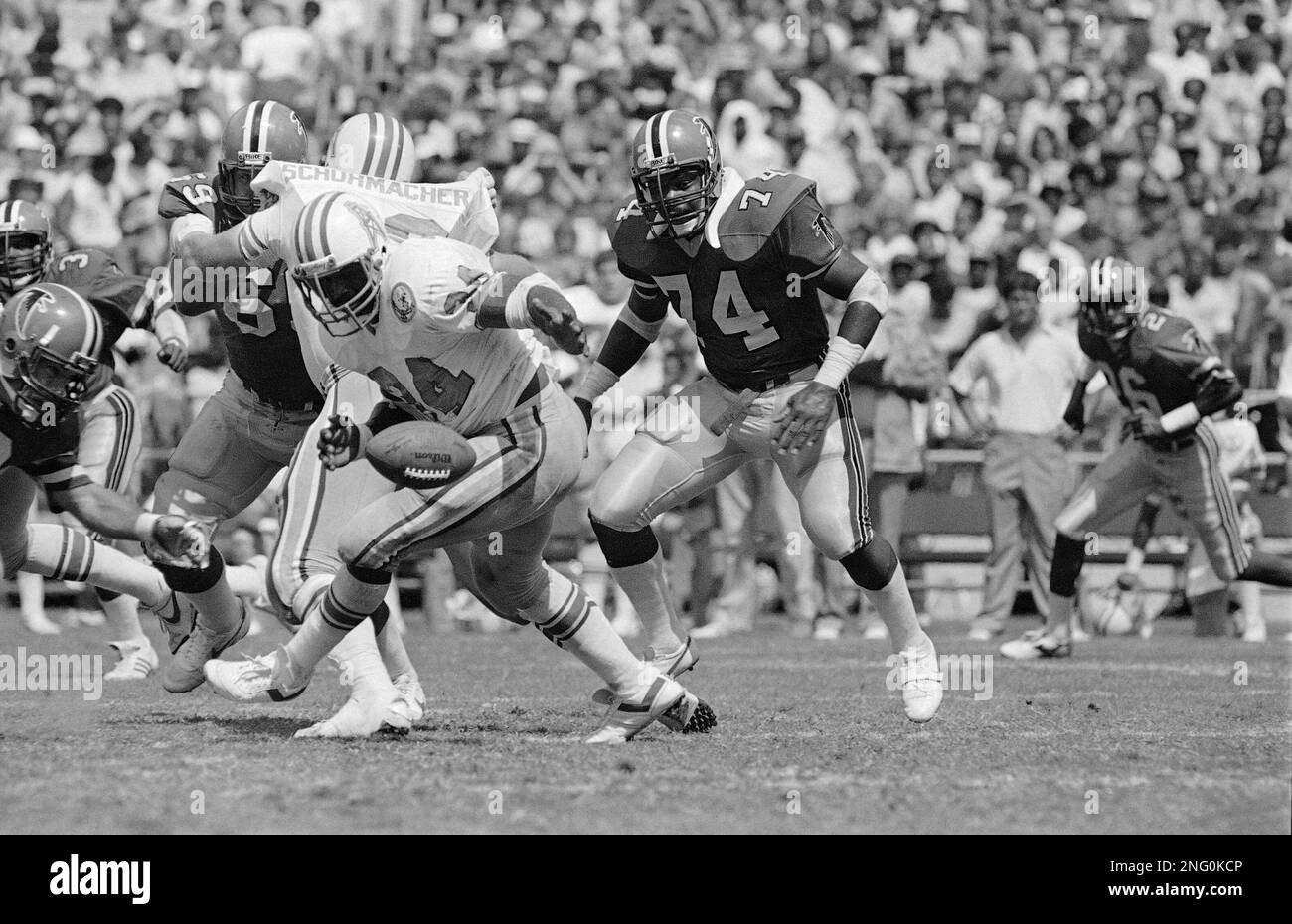 Houston Oilers Earl Campbell (34) is hauled down by Raiders Ted Hendricks  (83) after seven years