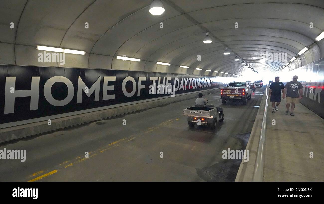 Cars and golf carts drive through the Turn 1 tunnel at Daytona