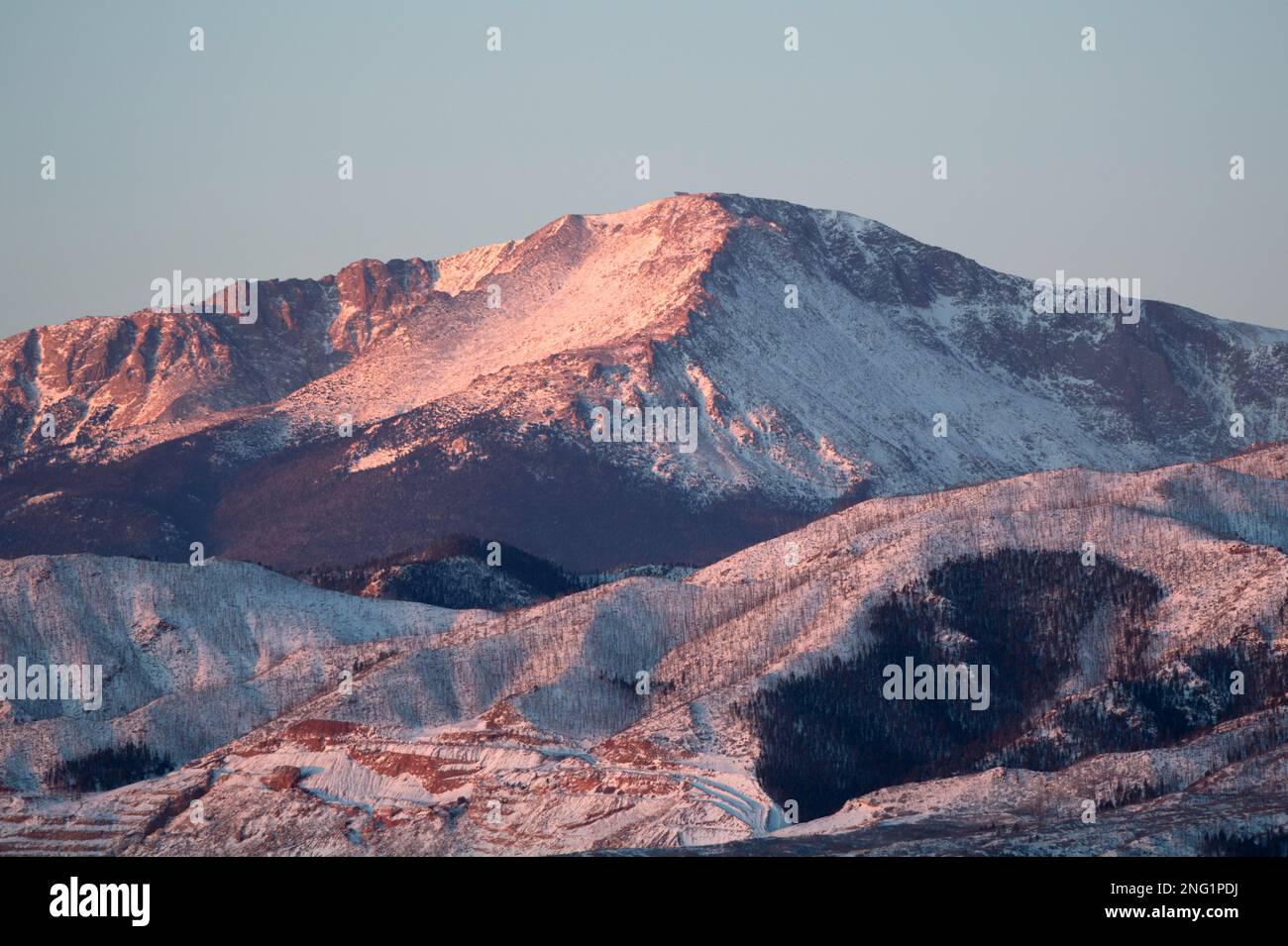 Alpenglow and sunrise on PIkes Peak, after a winter storm.  Pikes Peak is 14, 100 feet high, and towers over Colorado Springs, Colorado. Stock Photo