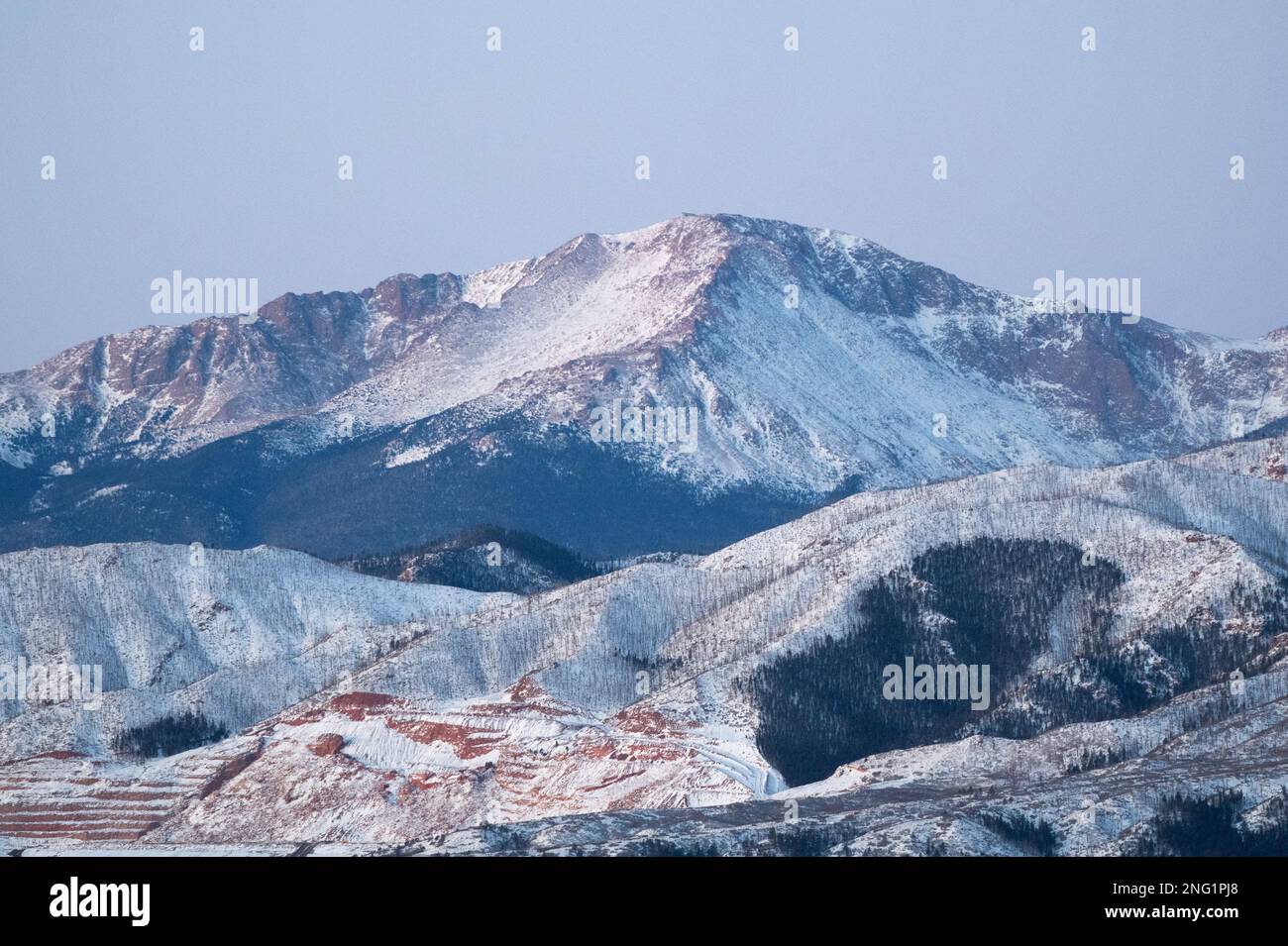 Alpenglow and sunrise on PIkes Peak, after a winter storm.  Pikes Peak is 14, 100 feet high, and towers over Colorado Springs, Colorado. Stock Photo