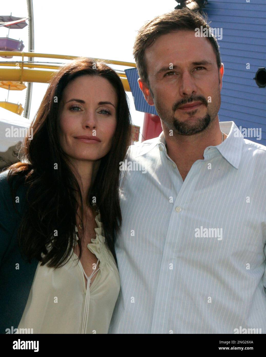 Hosts Courteney Cox, left, and her husband David Arquette pose at a