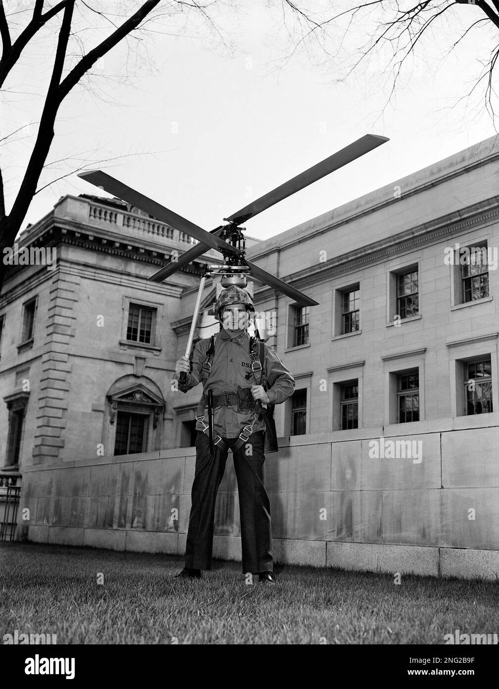 T/Sgt. Daniel Murphy demonstrates the "Hoppi-Copter," a one-man helicopter strapped to the shoulders like a knapsack and capable of flying a fully armed man, in Washington on Feb. 15, 1952. This is an actual model, but Sgt. Murphy didn't fly it. It came from inside Constitution Hall, part of an exhibit of Navy firepower and technology. (AP Photo/Harvey Georges) Stock Photo