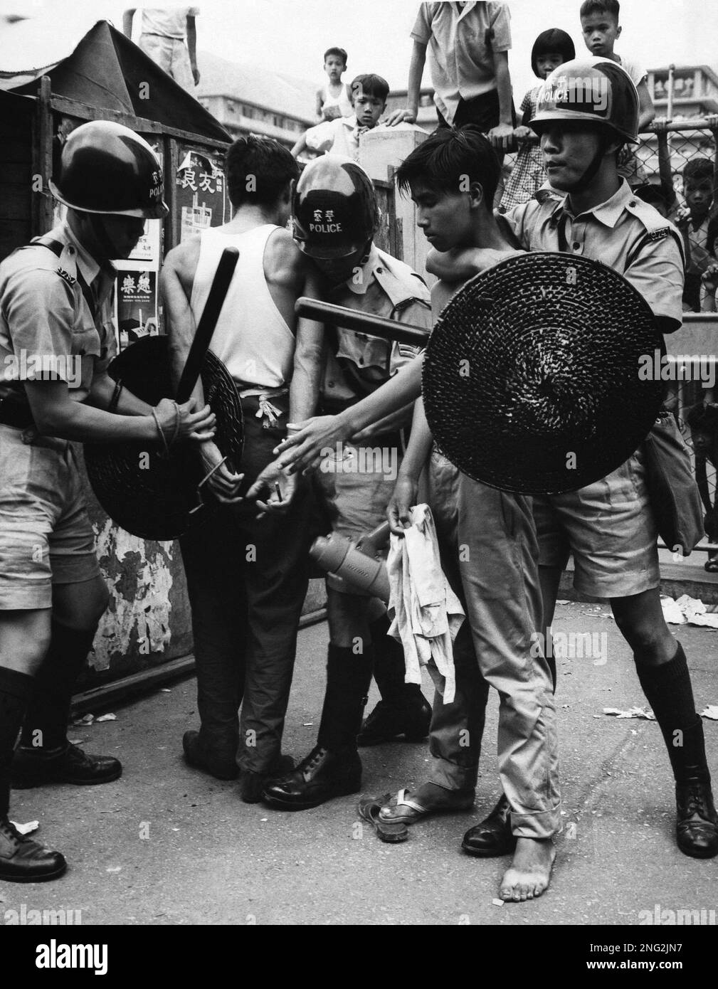 Riot policemen has throat choke hold on one young teenage rioter while