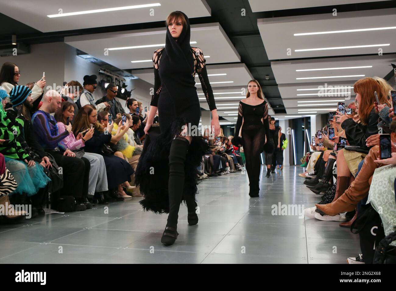 Models on catwalk mark fast fashion show in courtyard space hi-res