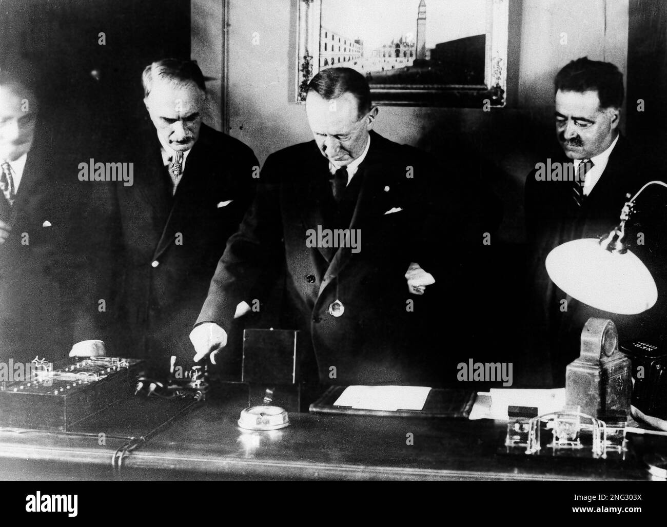 A group of unidentified men stand with the original Edison phonograph