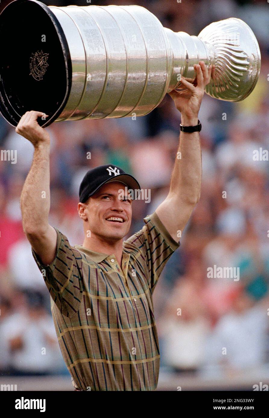 New York Rangers' Mark Messier, sporting a New York Yankees' cap, shows the  Rangers' Stanley Cup to the crowd at Yankee Stadium before the game between  the Yankees and the Minnesota Twins,, image size:893x1390