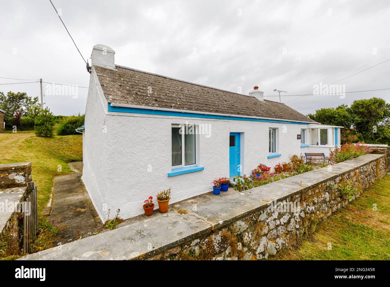 White rendered bungalow with blue paintwork in Marloes, a small village
