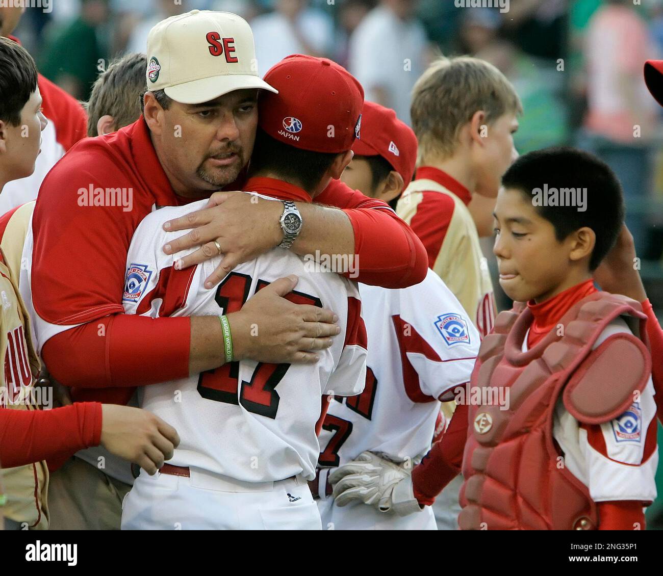 Warner Robins, coach Mickey Lay hugs losing Tokyo, Japan