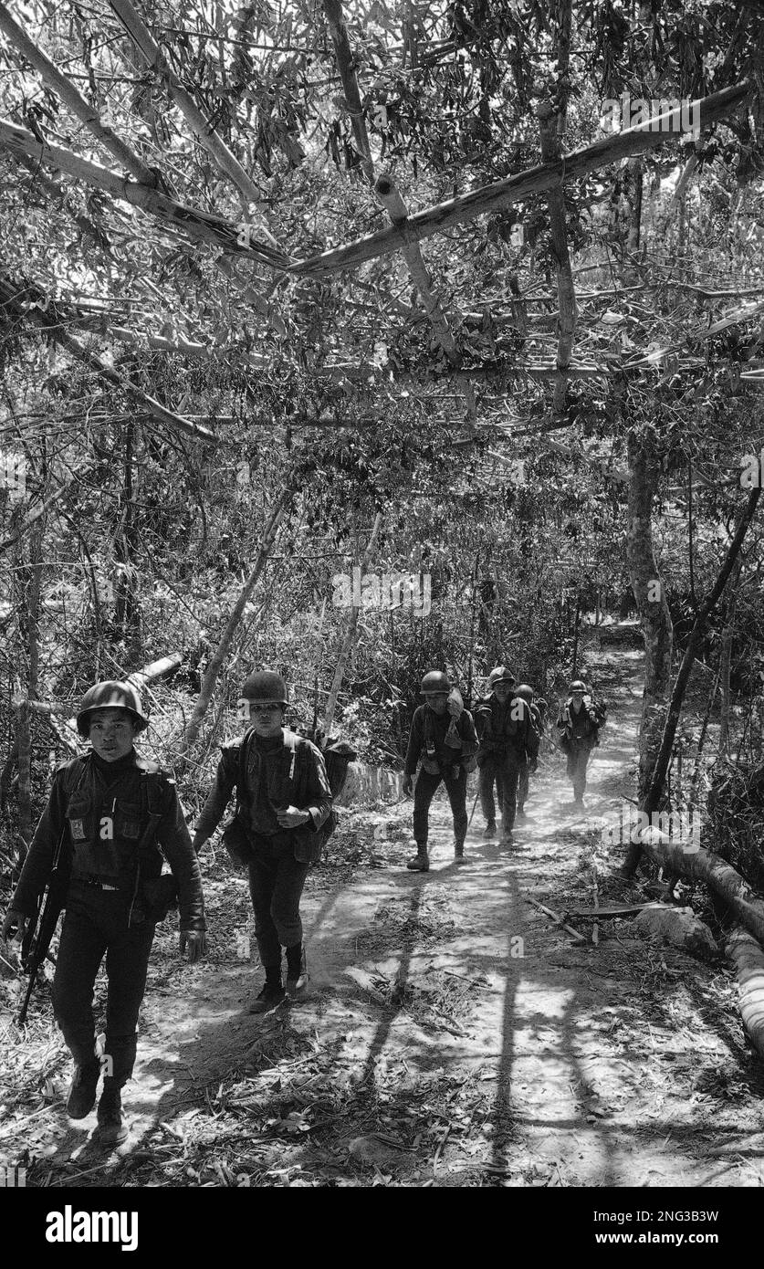 South Vietnamese troops walk along a section of the Ho Chi Minh trail, inside Laotian border