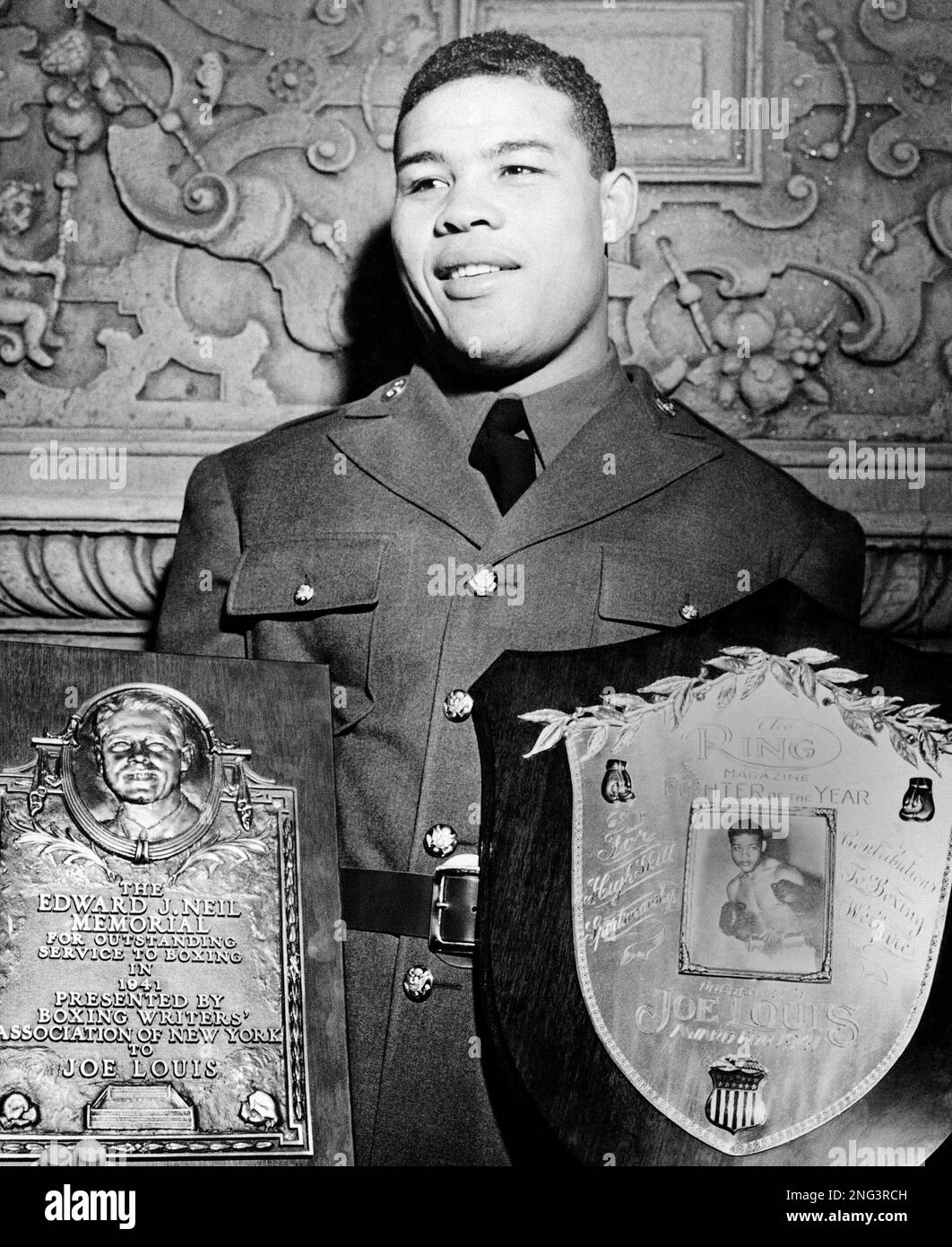 Private Joe Louis heavyweight champion proudly holds the Edward J.Neil  award presented to him by the Boxing Writers Association in New York on  January 22, 1942. Louis also received the Ring Magazine