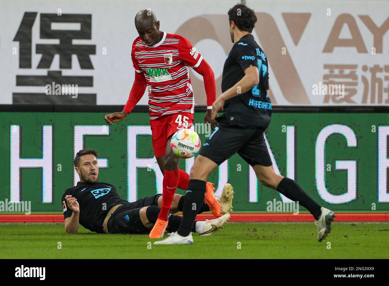 Augsburg, Germany. 17th Feb, 2023. Soccer: Bundesliga, FC Augsburg - TSG  1899 Hoffenheim, Matchday 21, at WWK-Arena, Augsburg's Kelvin Yeboah (m)  and Hoffenheim's Ermin Bicakcic (l) fight for the ball. Credit: Christian