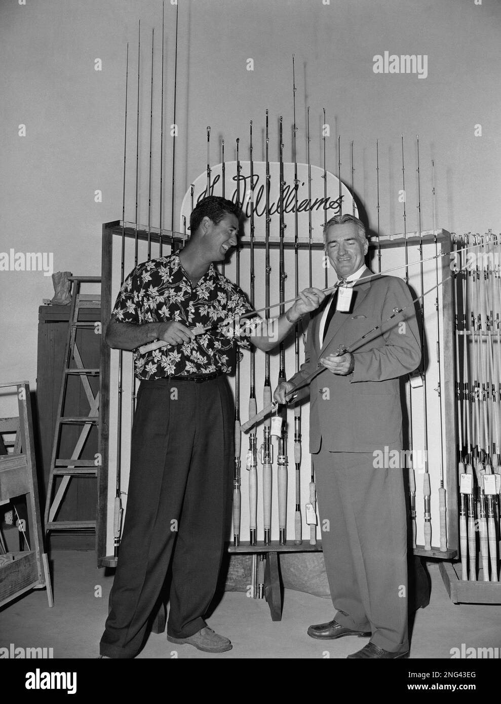 Ted Williams, left, Boston Red Sox slugger, discusses new item with Joe  Brooks, right, an associate, at Southern Tackle Distributors, the fishing  tackle company Williams runs in Miami, Fla., April 12, 1954. (