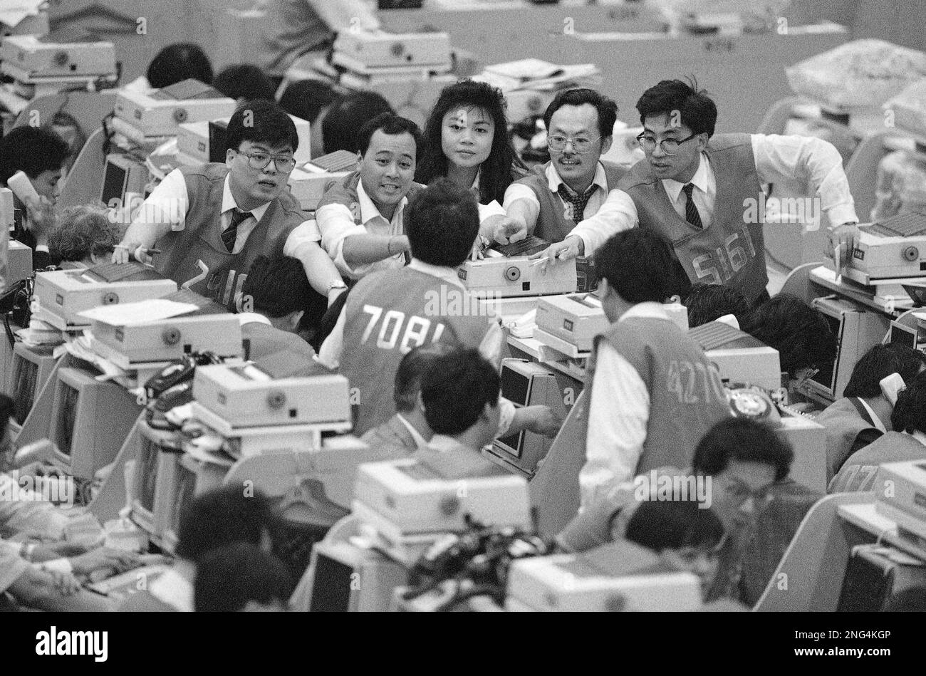 Floor traders on the Hong Kong Stock Exchange signal their transactions