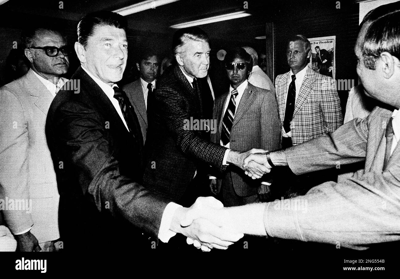 Actor Jimmy Stewart, right shakes hands as he helps Ronald Reagan, left