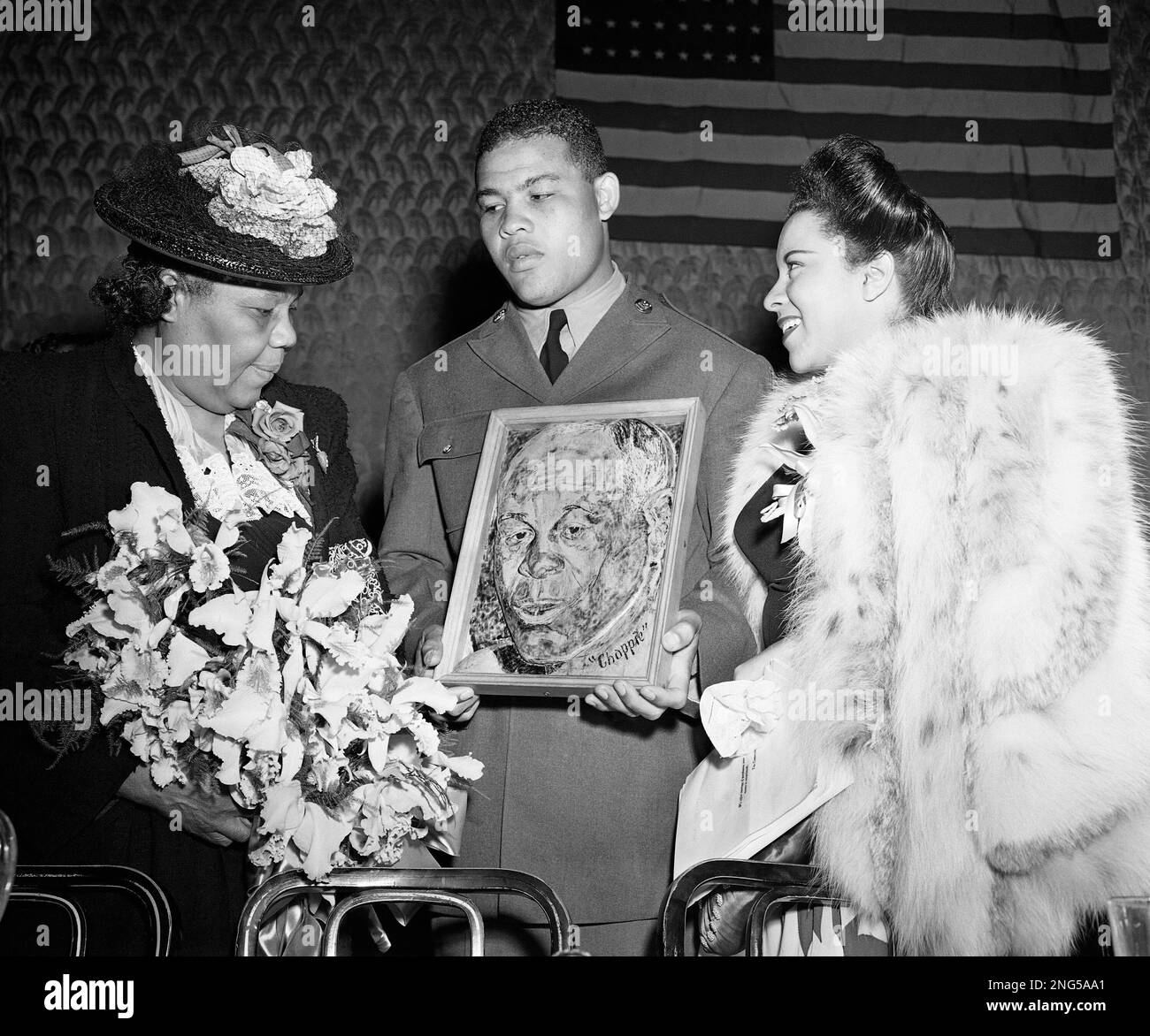 Private Joe Louis, the heavyweight boxing champion, holding a plaque of