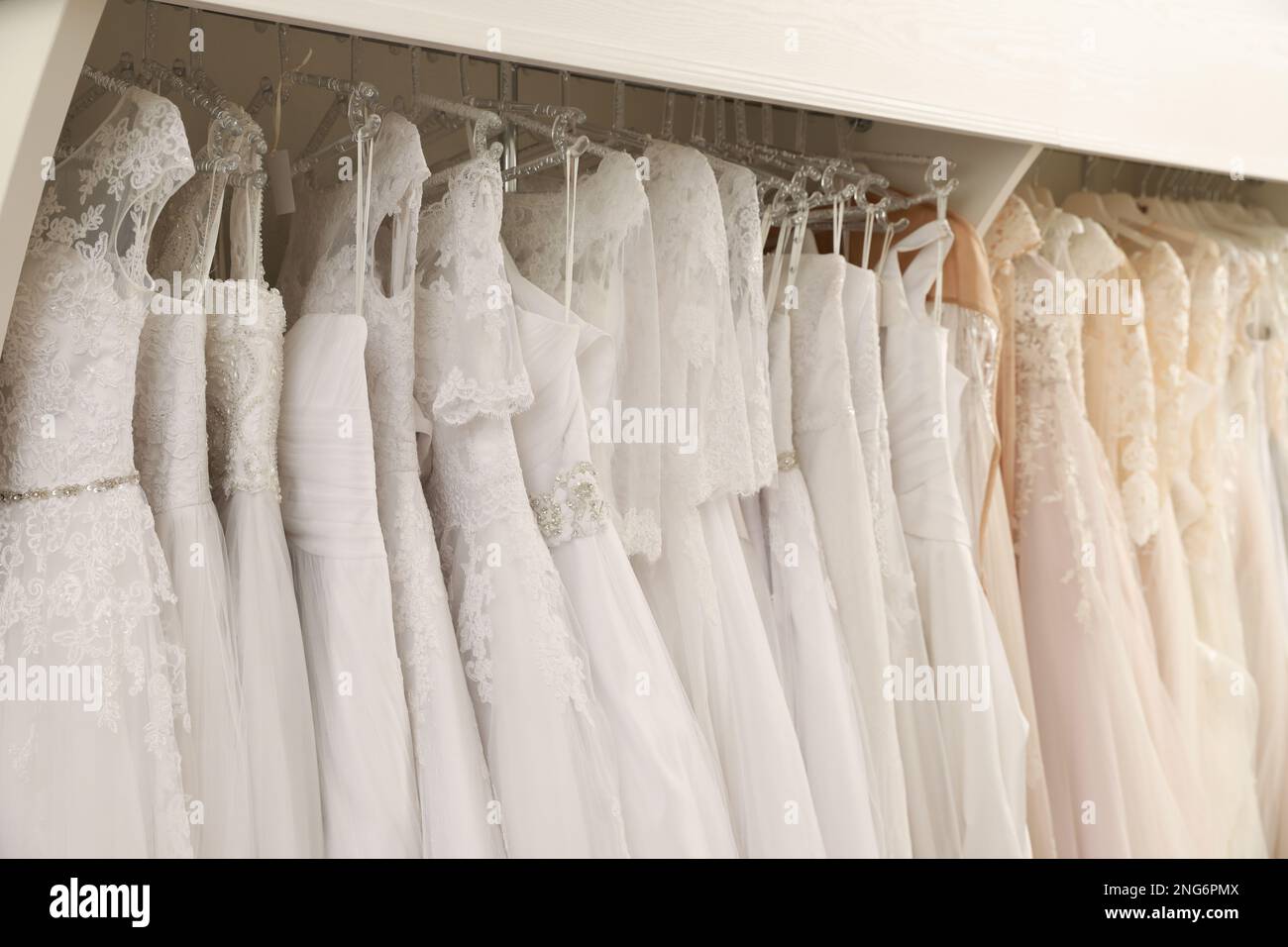 Different wedding dresses on hangers in boutique Stock Photo - Alamy