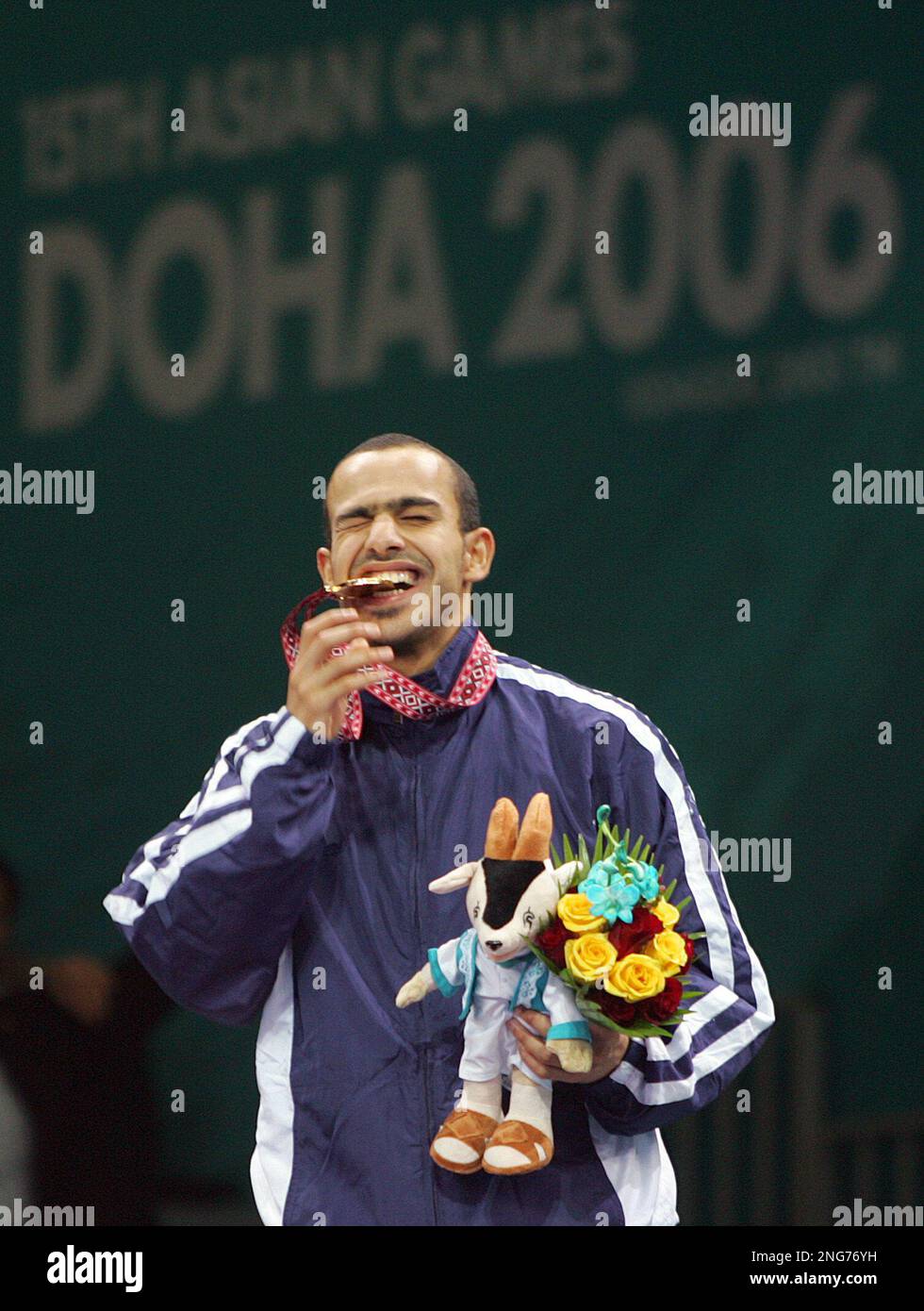 Abdullah Al Otaibi of Kuwait bites the gold medal he won in the Men's