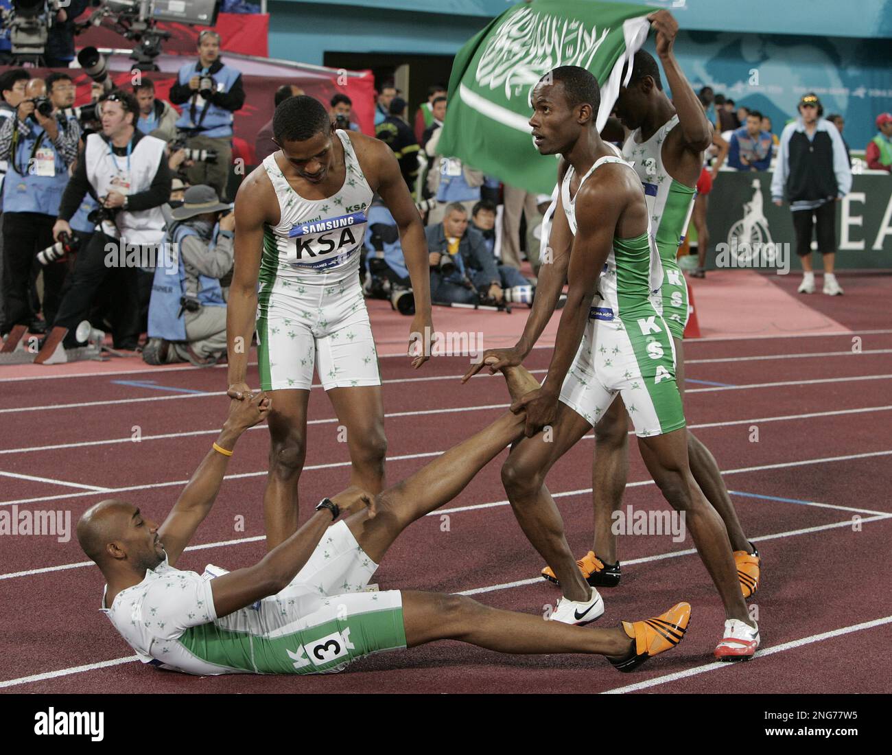 Saudi Arabia's Hamdan Awdah Al Bishi, bottom left, is assisted by