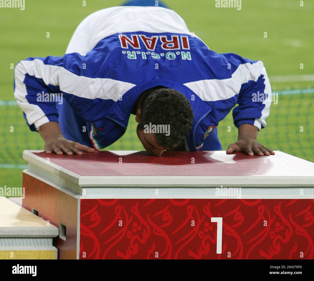 Iran's Ehsan Hadadi kisses the medal podium before receiving the gold