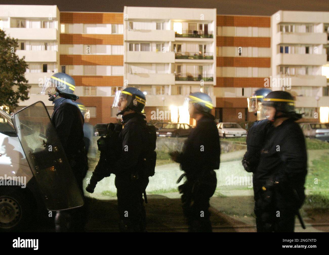 Riot police officers patrol during a police raid in Les Mureaux, west ...
