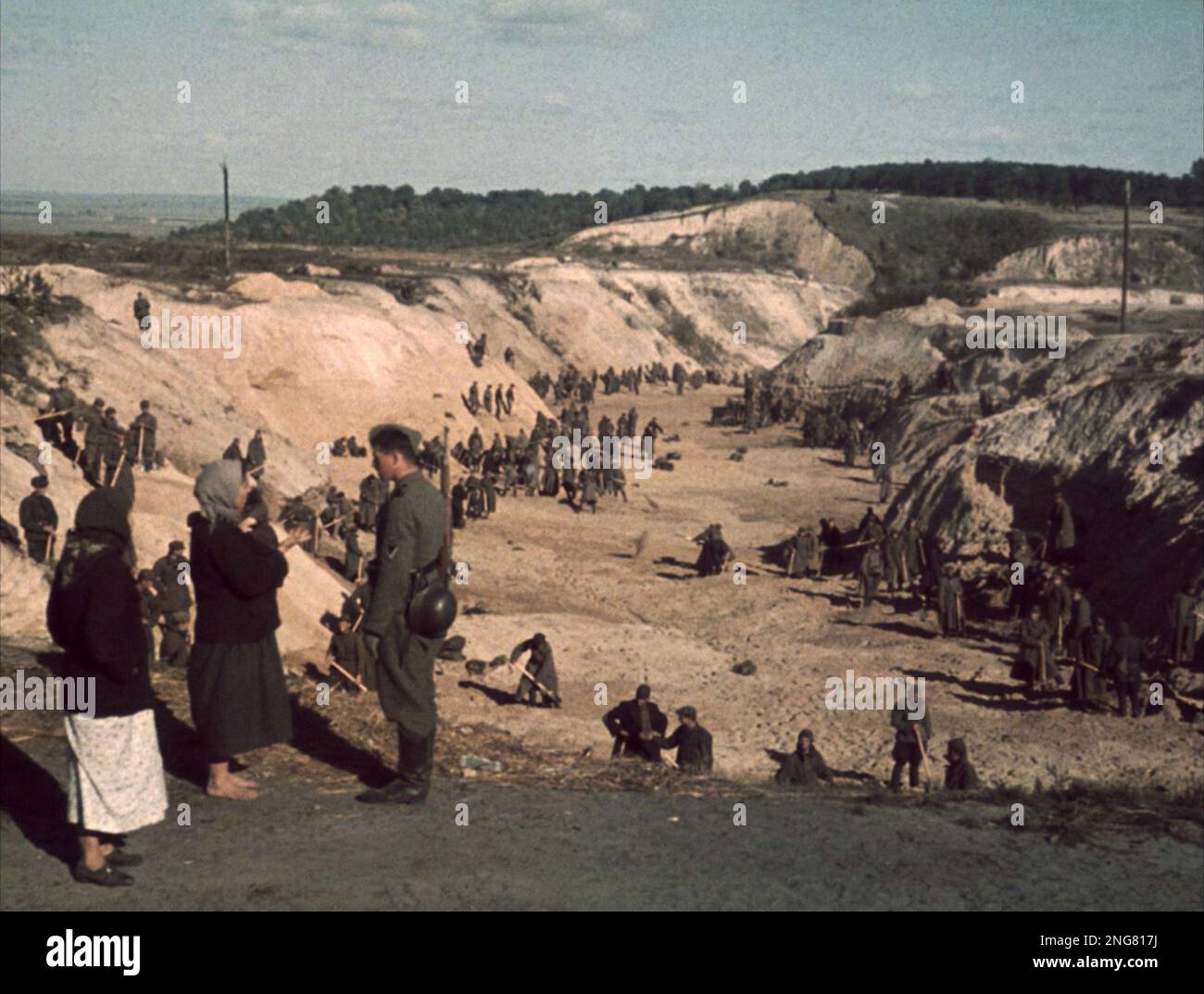 The early phase of the Holocaust was not with gas chambers but mobile execution squads known as Enisatzgruppen. Their task was to roam behind teh front lines shooting all the Jews they could.  This photo shows Soviet POWs covering a mass grave after the Babi Yar massacre, October 1, 1941. Stock Photo
