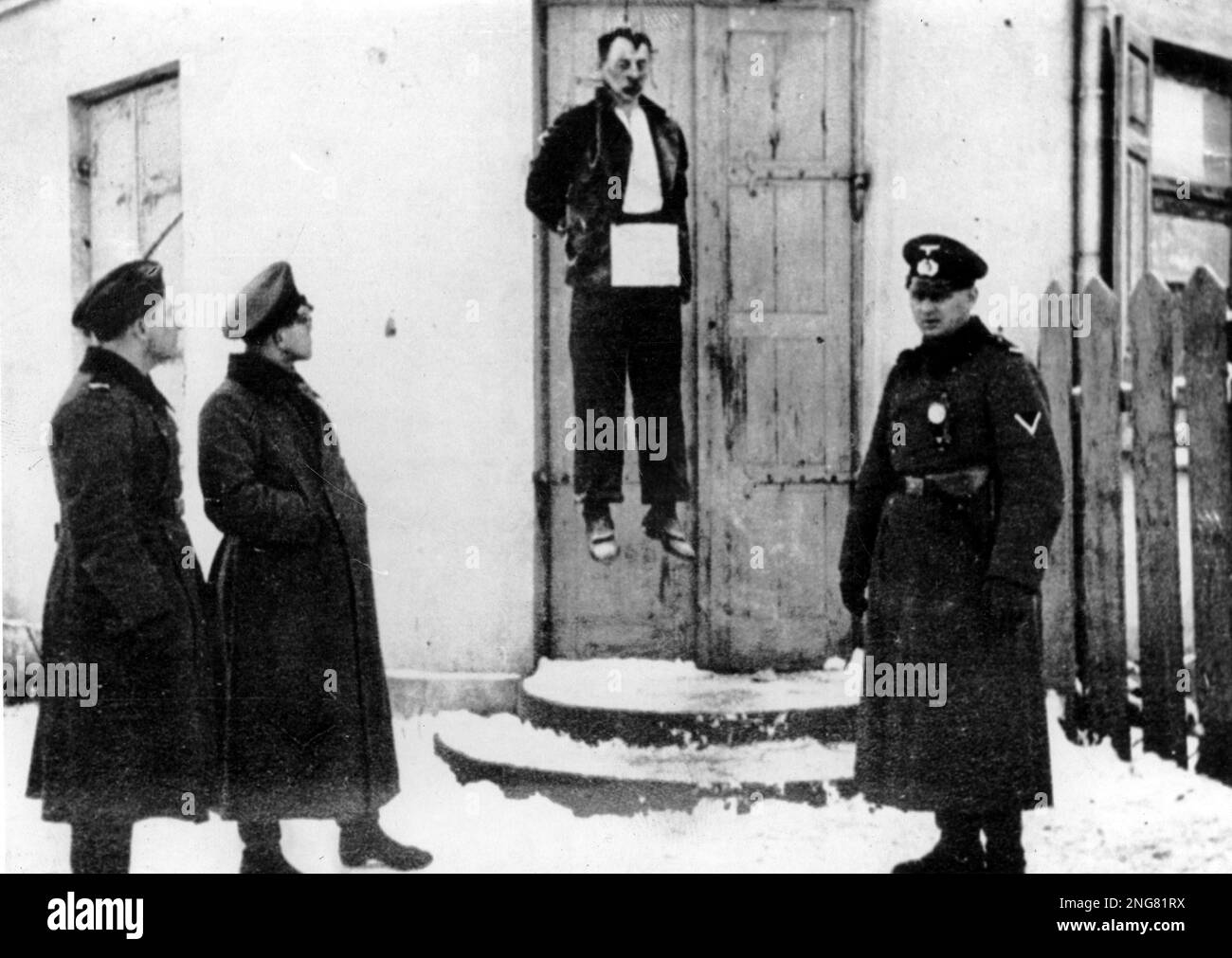 German officers looking at the hanged body of a civilian man in Warsaw during WW2. Stock Photo
