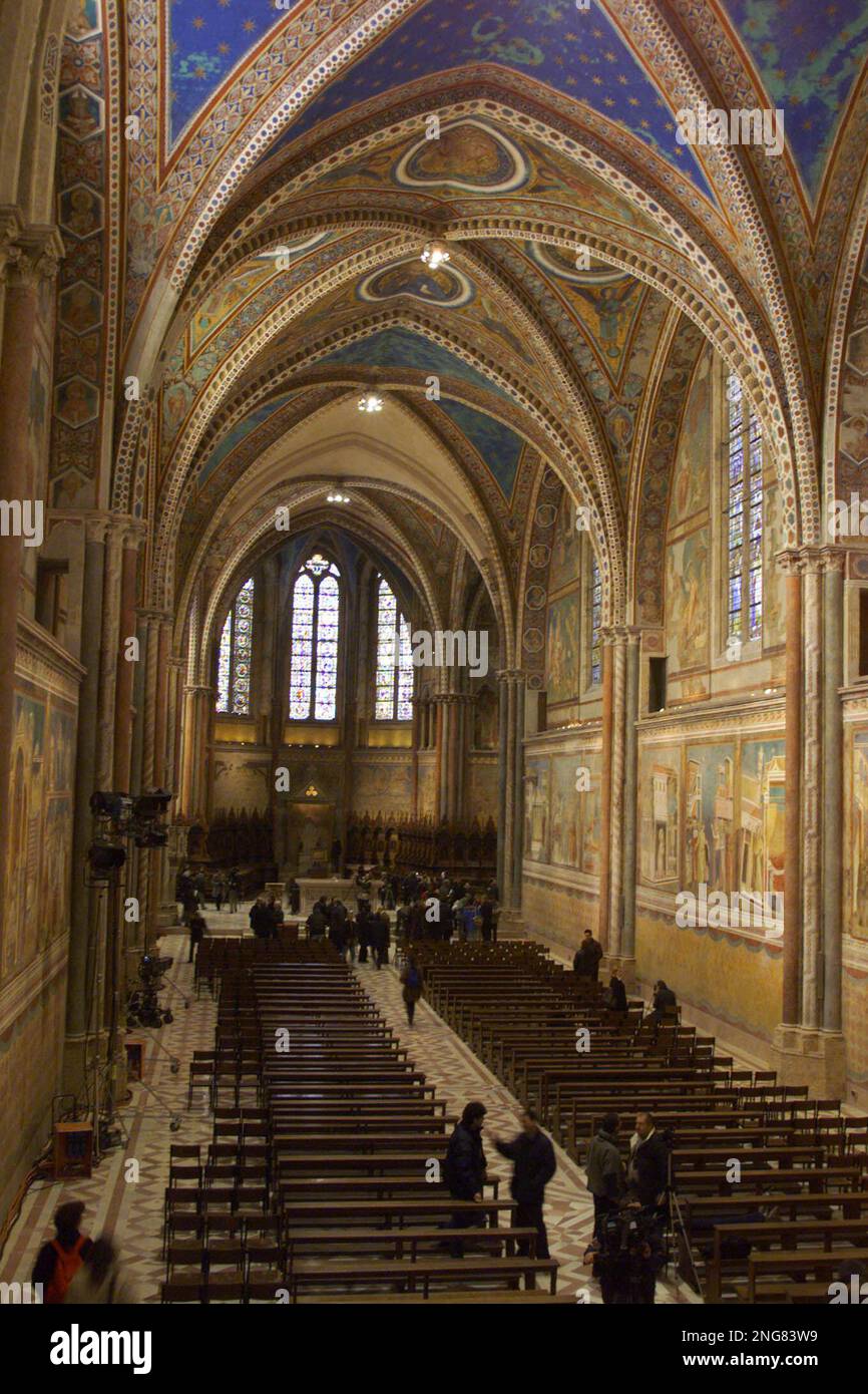 People walk in the main aisle of the Basilica of St. Francis of Assisi