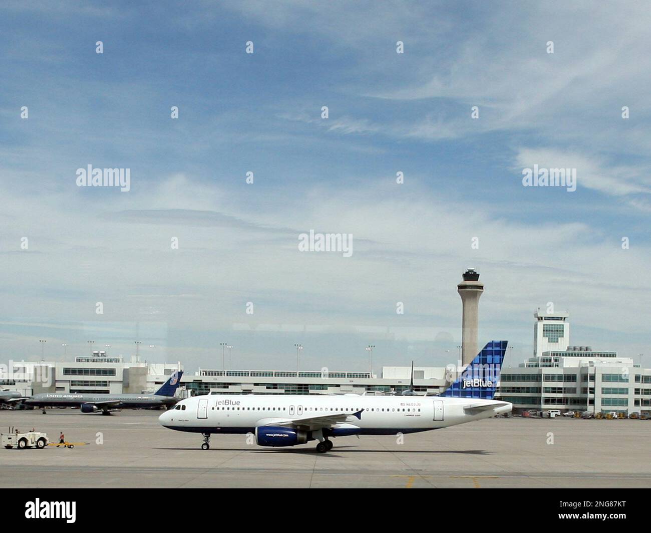 A tug pulls away from a JetBlue plane after pulling it away from a gate