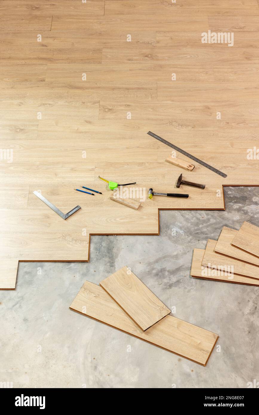 Worker Installing Interlocking laminate floor, home renovation Stock