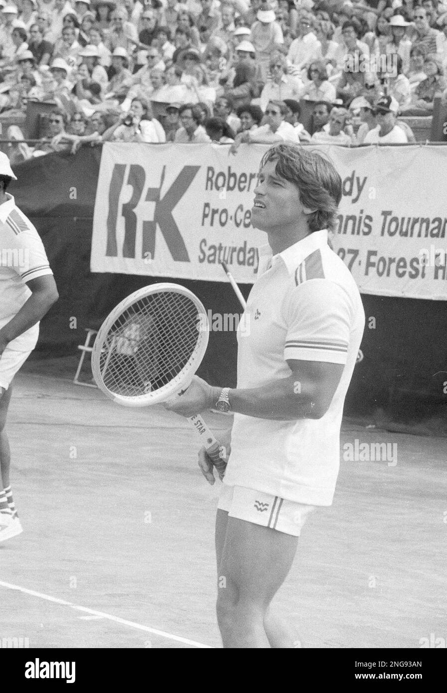 Actor and bodybuilder Arnold Schwarzenegger wields an extra large tennis  racquet as a gag before the start of the RFK Celebrity Tennis Tournament in  New York, Aug. 27, 1977. (AP Photo/Marty Lederhandler
