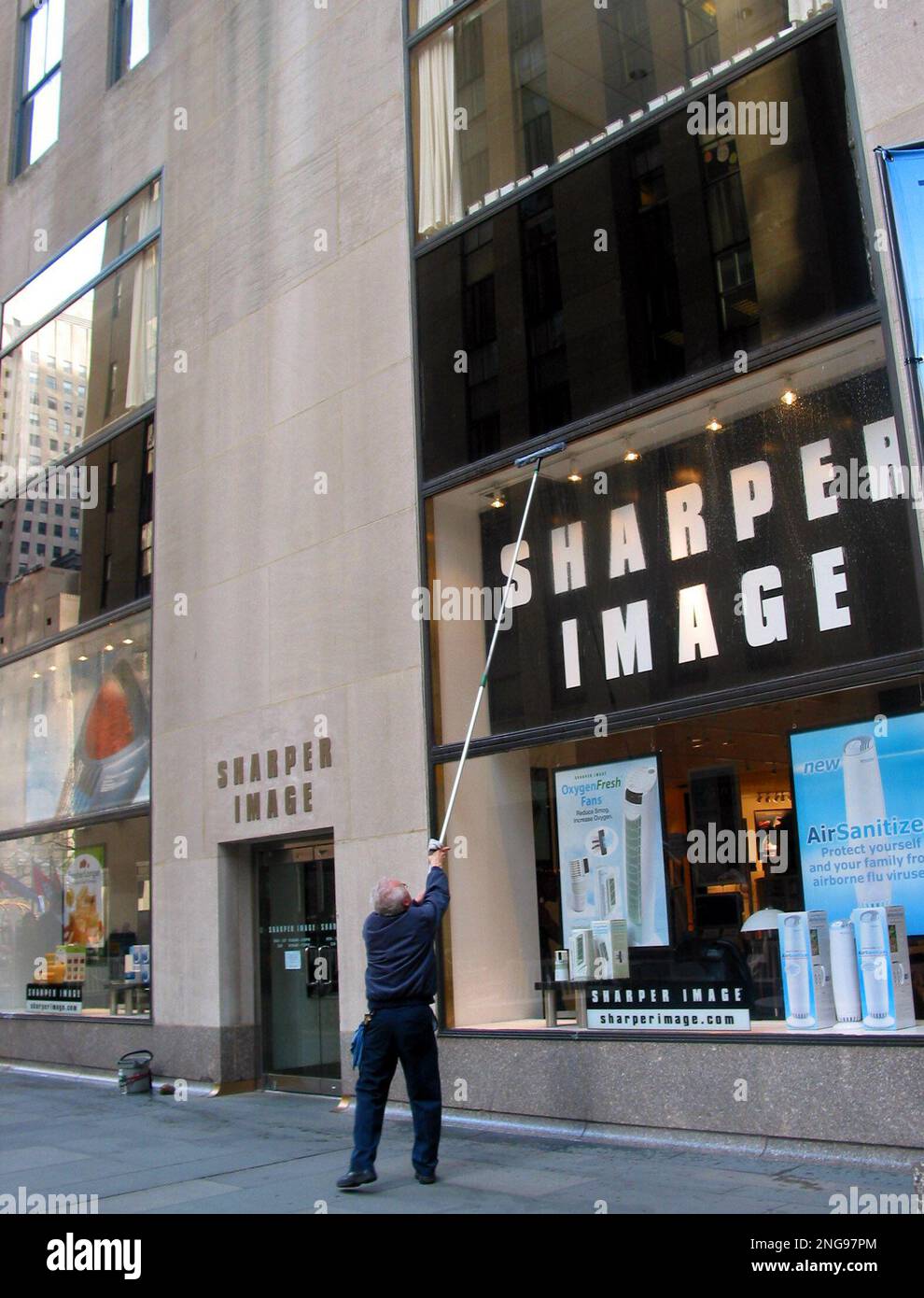 A man cleans the window of a sharper image store in new york on monday