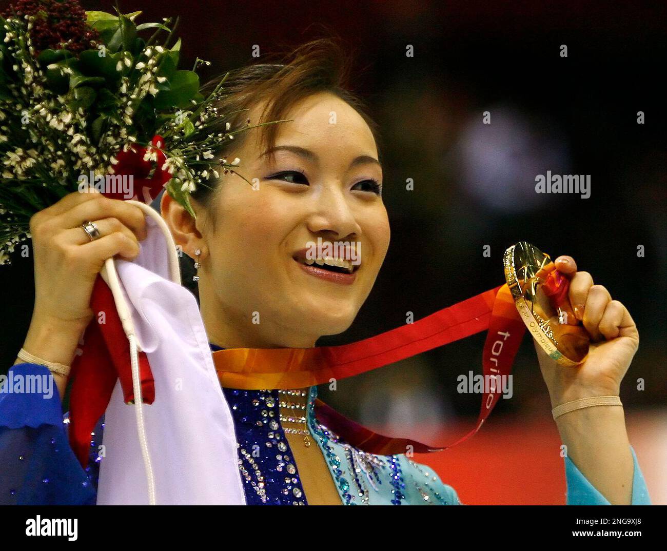 Japan's Shizuka Arakawa shows off her flowers and gold medal following ...