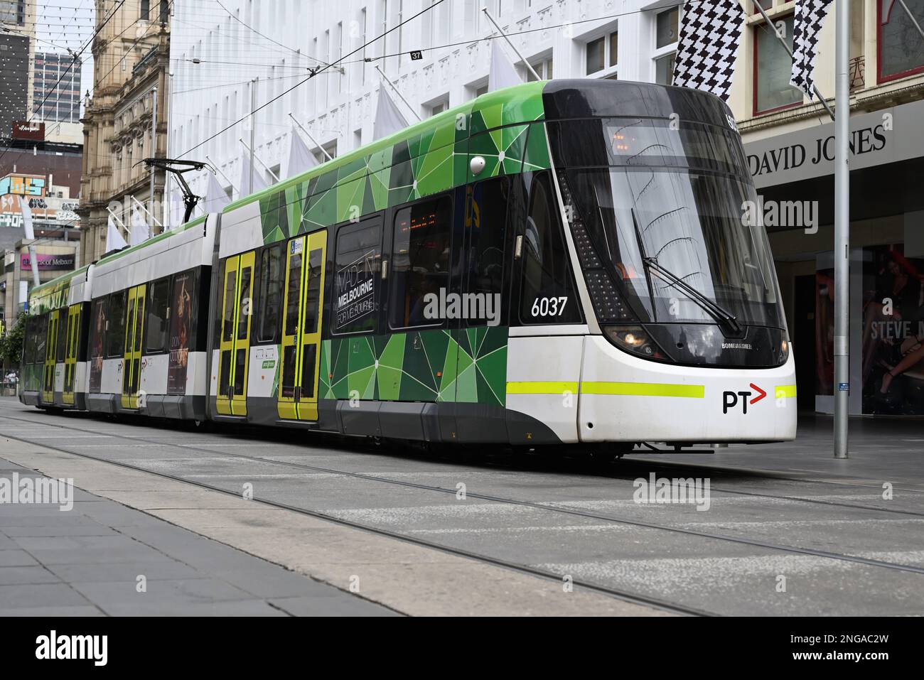 Low shot of a Bombardier Flexity (or E-class) tram, operated by Yarra Trams and featuring current PTV livery, travelling through Burke St Mall Stock Photo