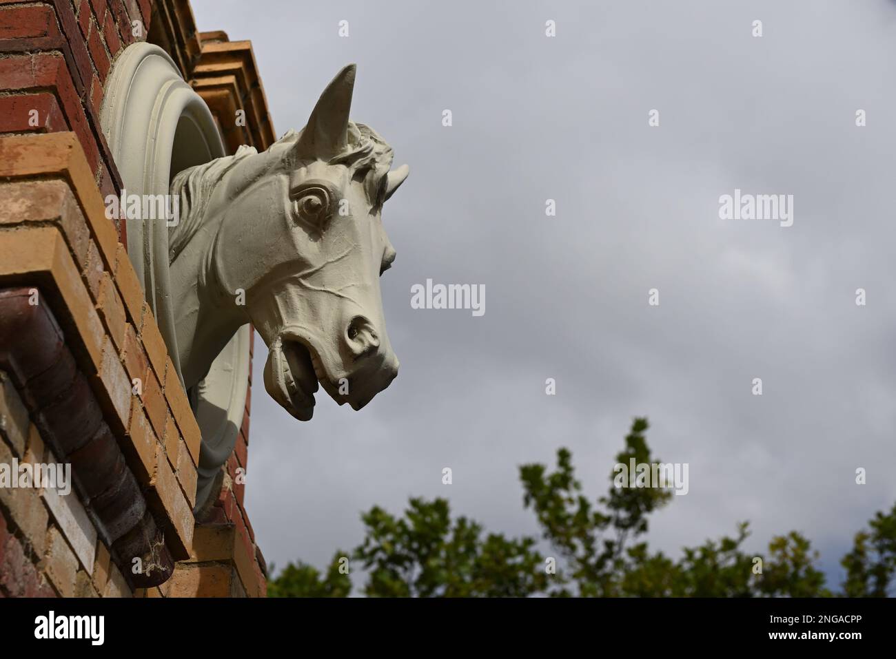 Sculpture of a horse head mounted to a brick wall at the former site of