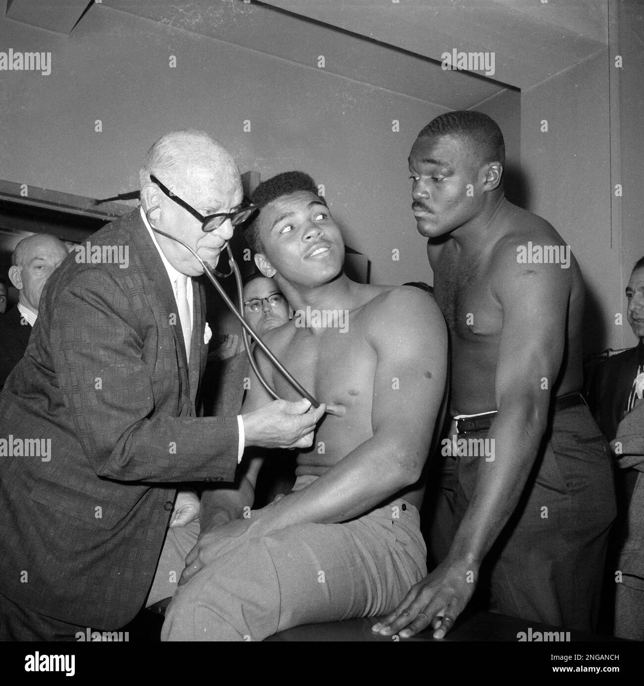 Heavyweight boxer Cassius Clay is examined by Dr. Samuel Swetnick of the  New York State Athletic Commission, as Clay and Doug Jones eye each other,  March 8, 1963, in New York. Clay,
