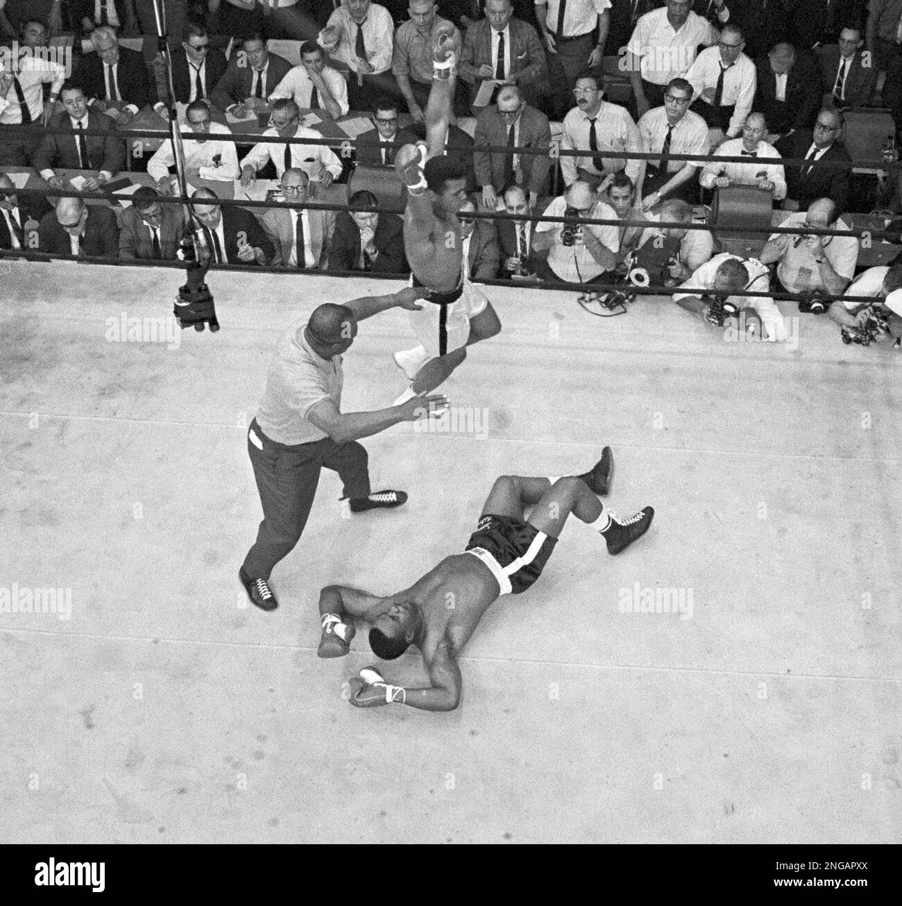 Heavyweight champion Muhammad Ali goes into a victory dance as referee