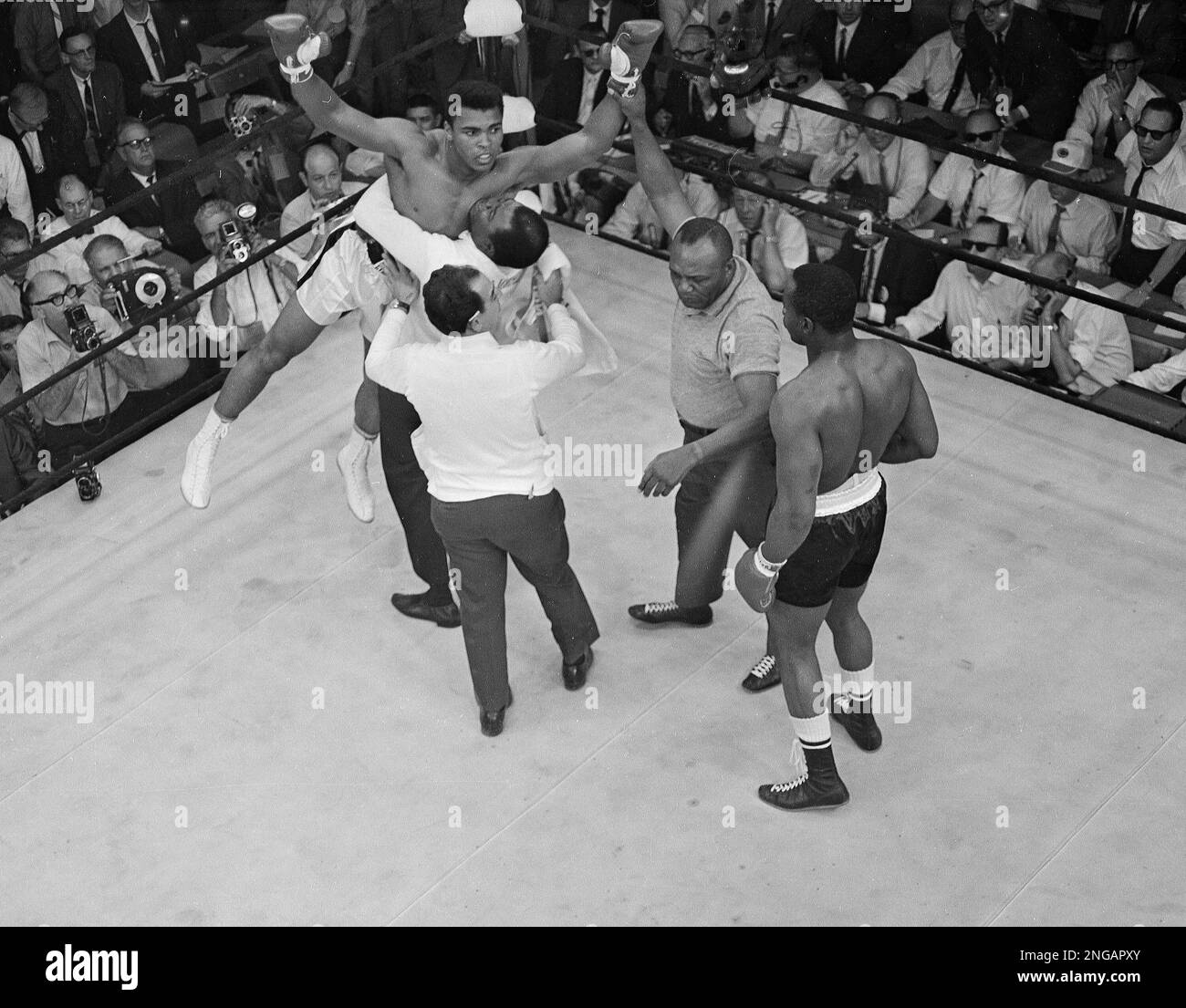 Heavyweight champion Muhammad Ali is lifted by happy handlers as
