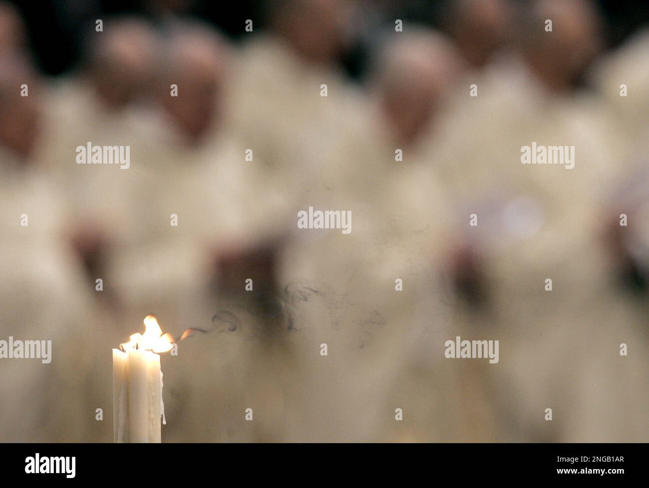 A candle blows as prelates pray during a Mass celebrated by Pope